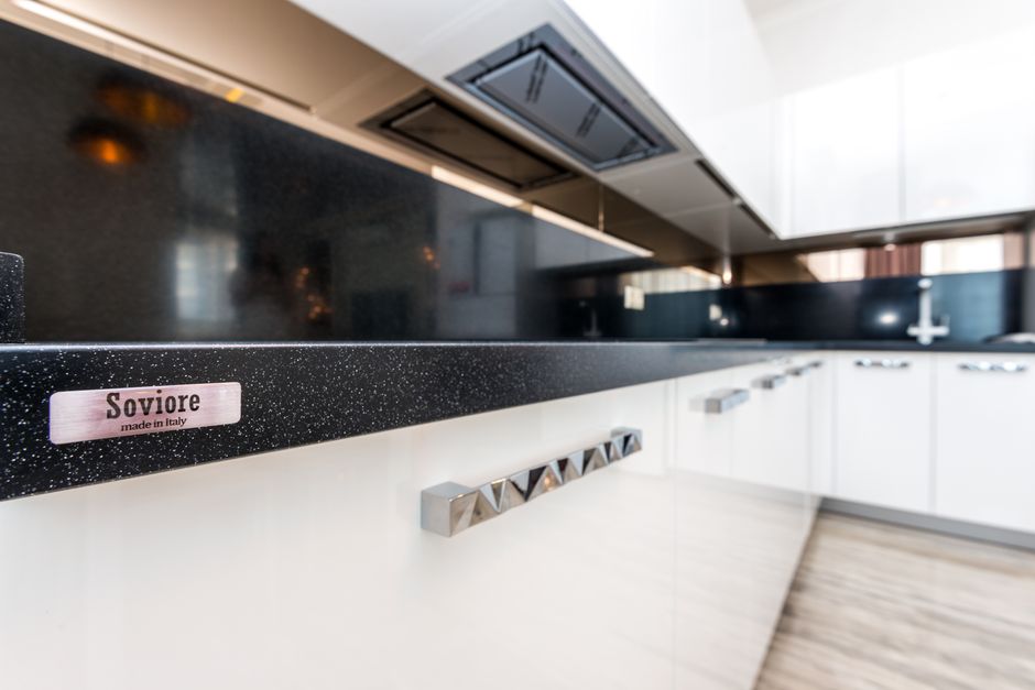Modern kitchen with white cabinets and a clean counter run.